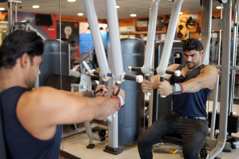 Man training chest on machine at Curve Fitness Pro, showing focus and strength in a modern gym setup.