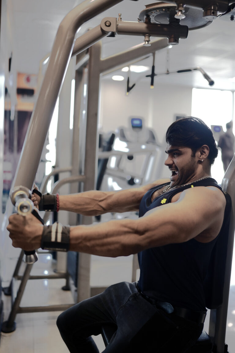 Man doing chest press on machine, showing intensity and strength with Curve Fitness Pro straps.